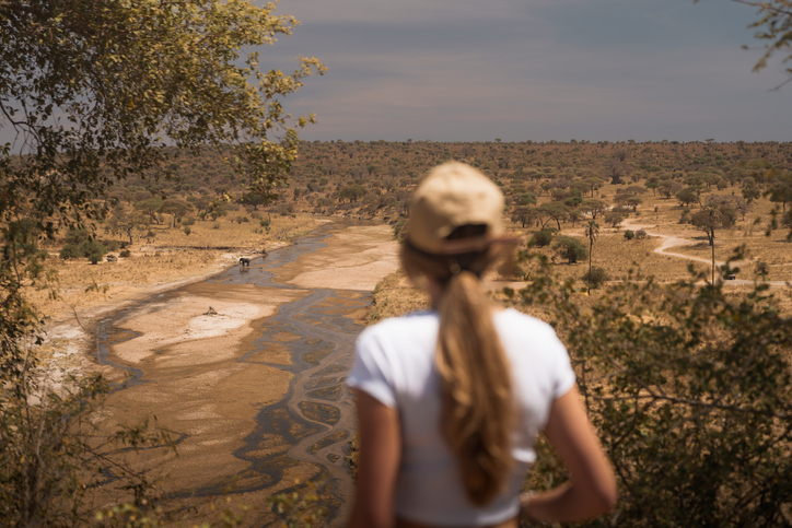 Woman watching elephants in Tarangire National Park during a safari.