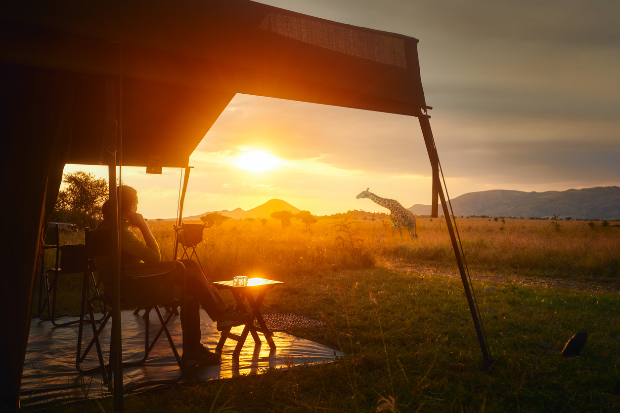 Person sitting at safari lodge watching sunset